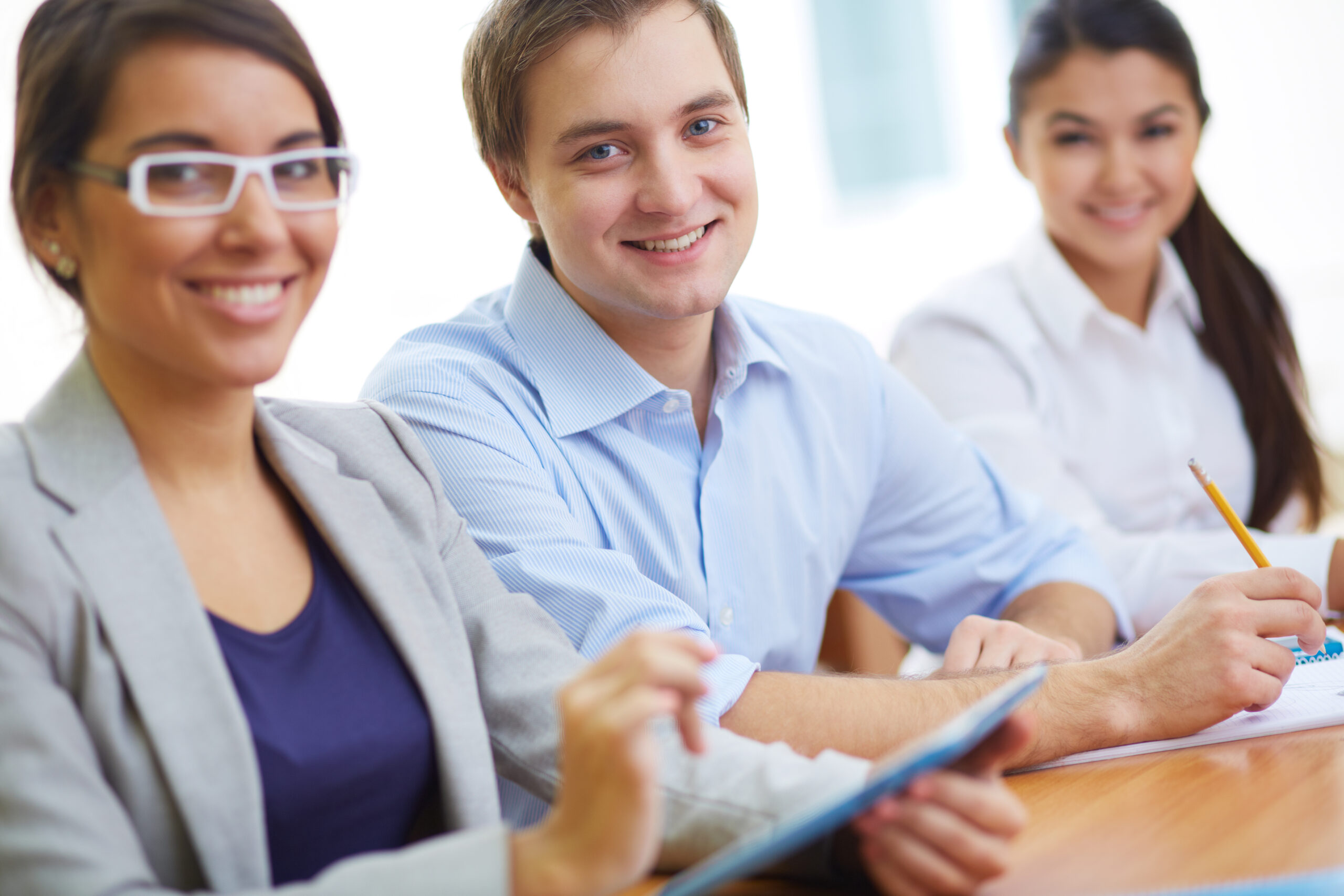 Portrait of handsome student looking at camera between two girls